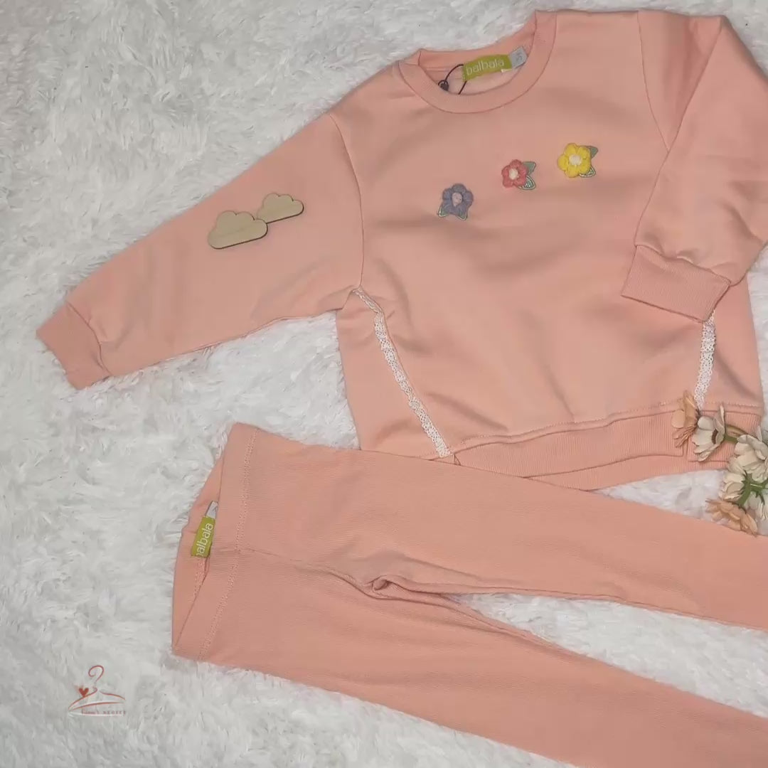 Ensemble fille avec sweat rose orné de petits nœuds et fleurs brodées, assorti à un legging ajusté, parfait pour un look confortable et tendance